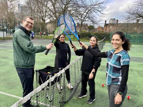 Coach Lee from Courtside Tower Hamlets with players at Community Tennis for Health, touching rackets after a session