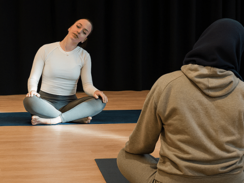 Two women doing relaxing yoga poses at Poplar Union community centre