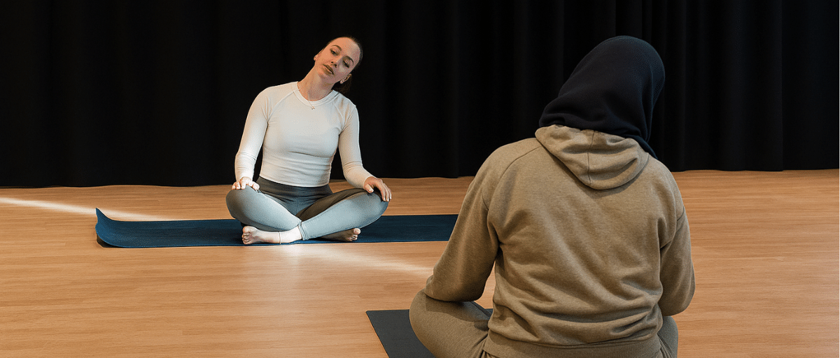 Two women doing relaxing yoga poses at Poplar Union community centre